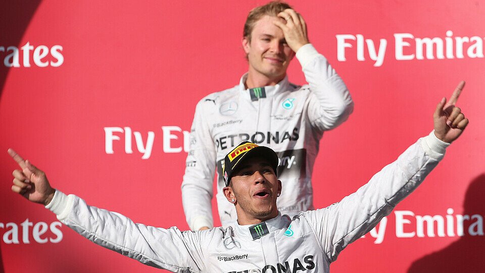 Sinnbild: Hamilton jubelt, Rosberg steht im Hintergrund, Foto: Mercedes-Benz