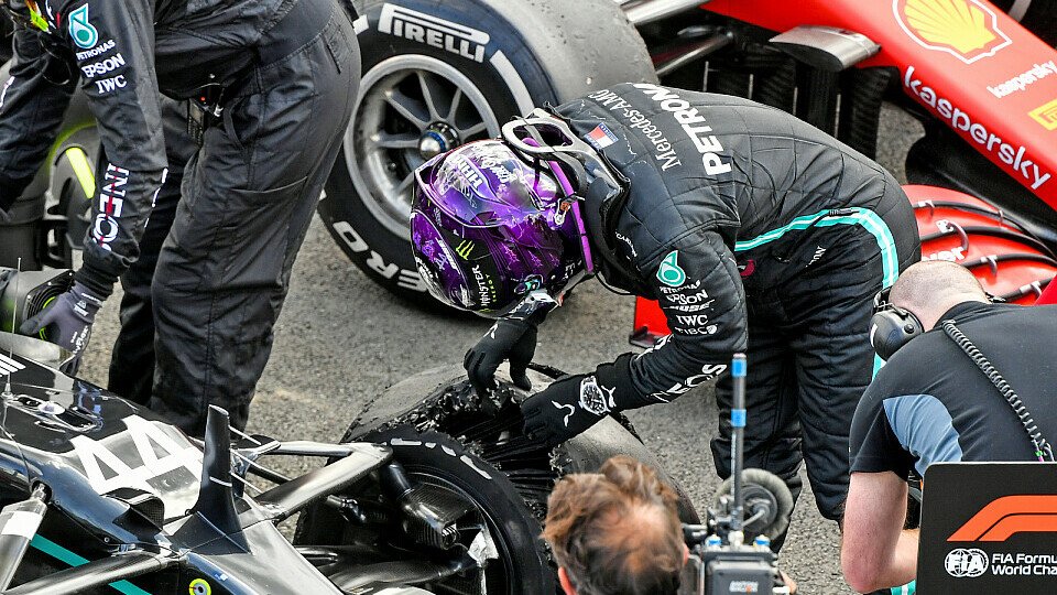 Lewis Hamilton wirft im Parc-ferme einen genauen Blick auf den defekten Reifen, Foto: LAT Images