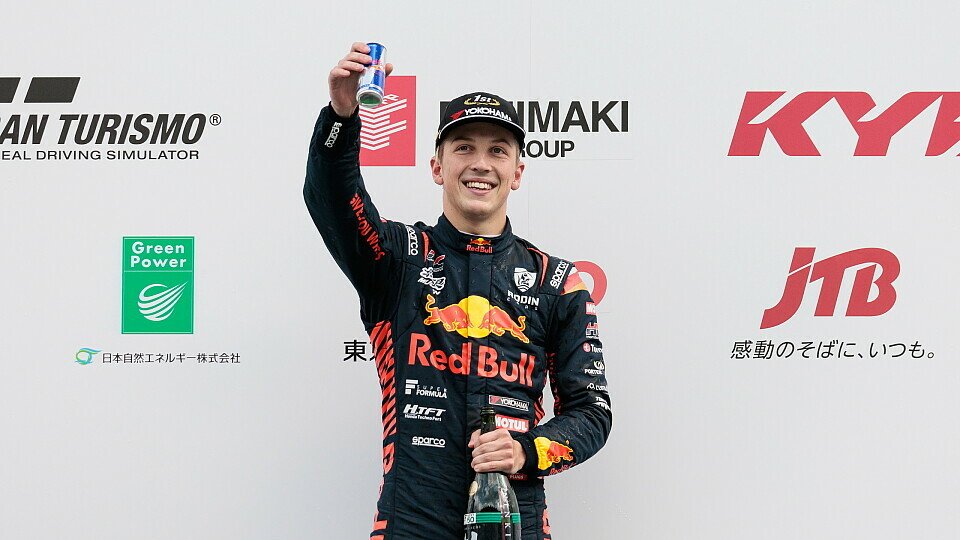 Liam Lawson jubelt mit einer Red-Bull-Dose in der Hand nach dem Sieg beim Super-Formula-Rennen 2023 in Fuji.