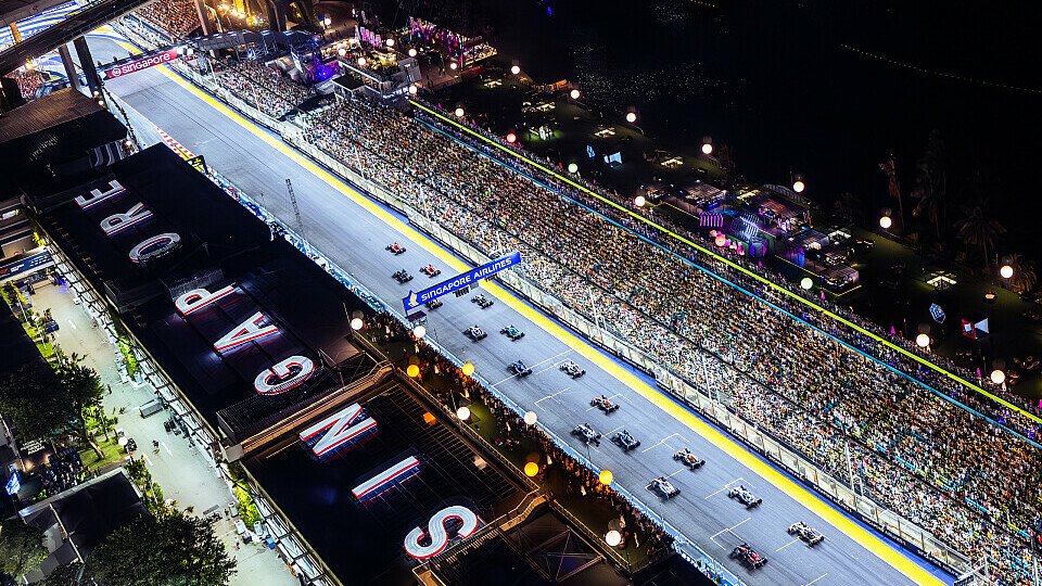 Start zum Singapur GP der Formel-1-Saison 2023 aus der Luft. Carlos Sainz führt das Feld in die erste Kurve an.