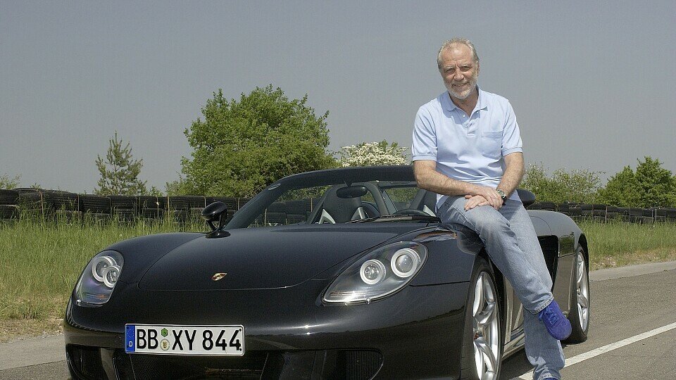 Roland Kussmaul sitzt auf einem Porsche-Sportwagen