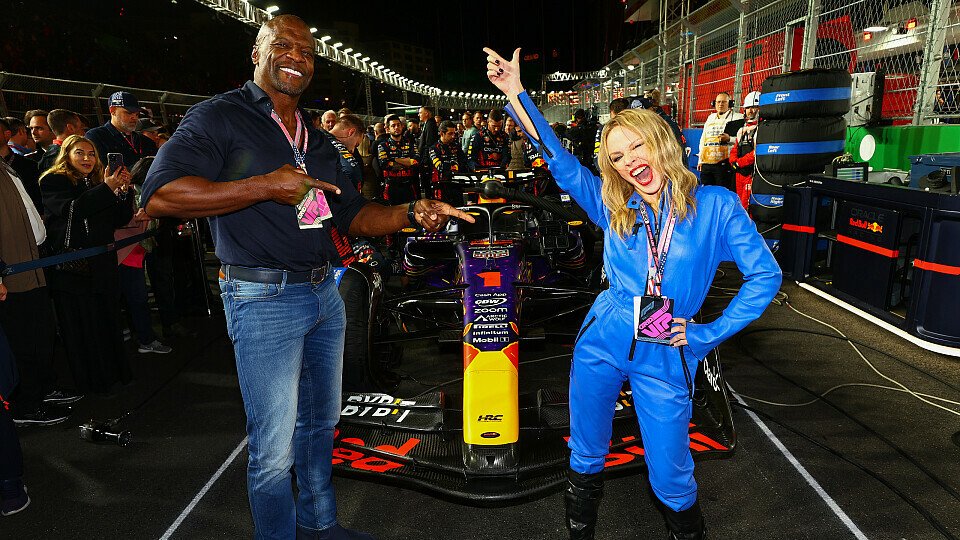 Terry Crews und Kylie Minogue posieren in der Startaufstellung vor dem Red Bull von Max Verstappen 