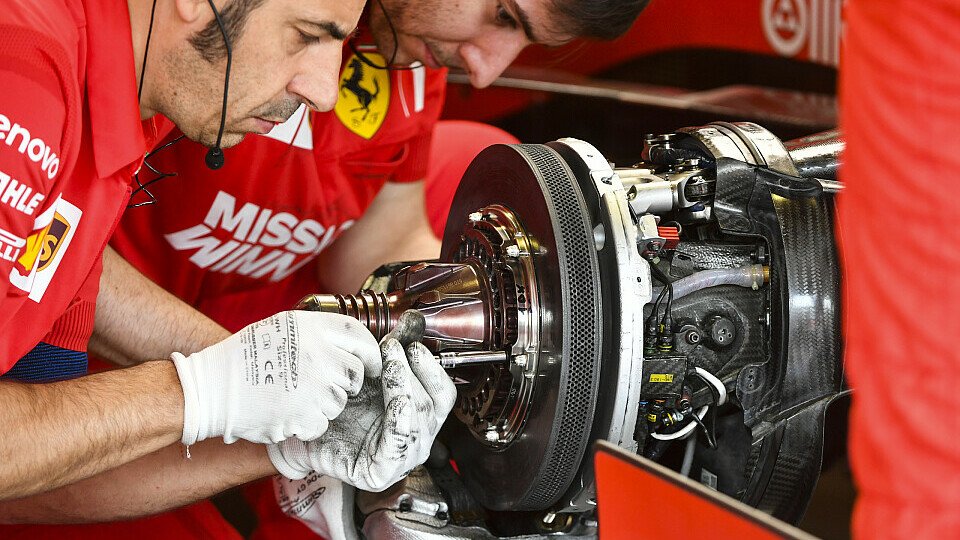 Ferrari-Mechaniker arbeiten an den Bremsen ihres Autos