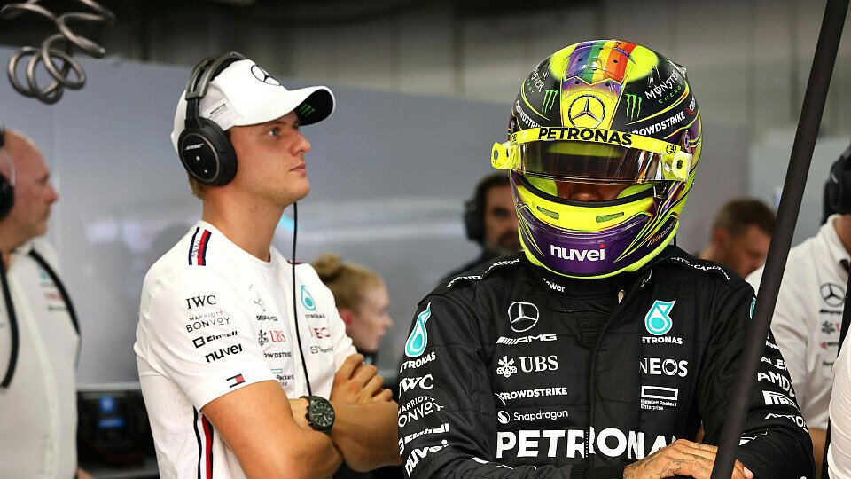 Mick Schumacher beobachtet das Geschehen in der Mercedes-Garage, Lewis Hamilton geht zu seinem Formel-1-Auto.