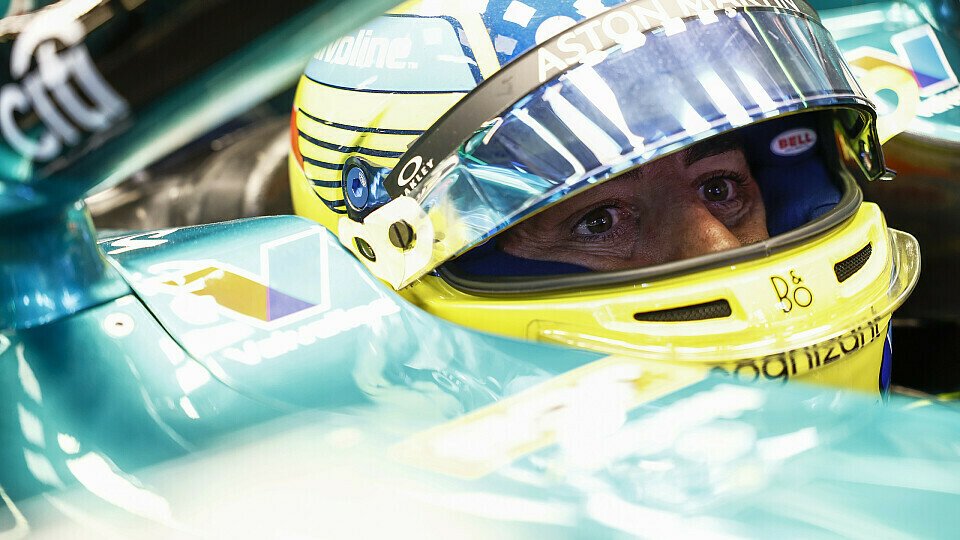 Fernando Alonso sitzt fokussiert in seinem Aston Martin Formel-1-Auto, das Visier seines Helms ist offen.