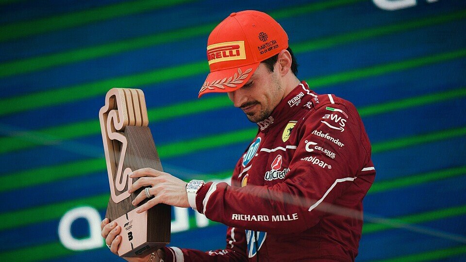 Ferrari-Fahrer Charles Leclerc mit Pokal auf dem Podium Ferrari-Fahrer Charles Leclerc mit Pokal auf dem Podium