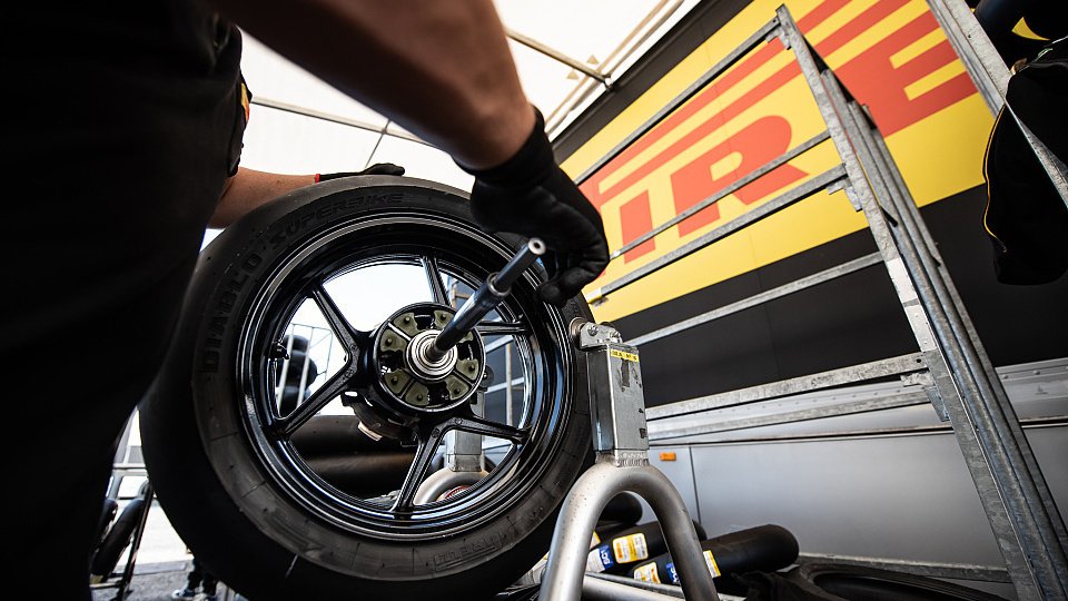 Un mécanicien vérifie un pneu de superbike Pirelli