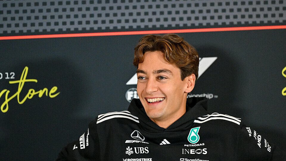 Mercedes-Pilot George Russell lacht auf dem Sofa bei der F1-Pressekonferenz von Silverstone