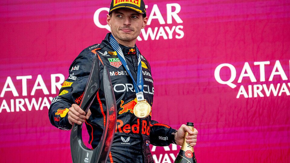 Max Verstappen auf dem Podium mit Pokal, Medaille und Siegerchampagner