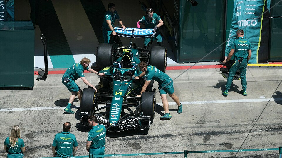 Mechaniker schieben Aston Martin in die Box